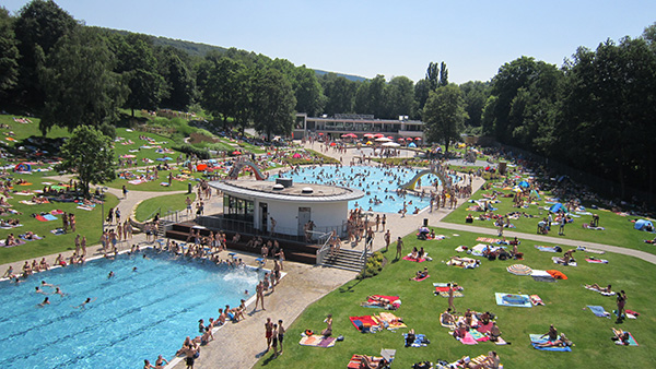 Viele Schwimmbecken und Liegewiesen im Südbad. Viele Menschen befinden sich auf den Wiesen